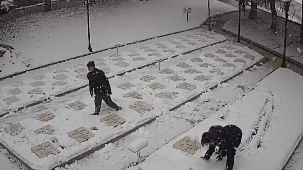 Çanakkale’de 2 genç, beyaza bürünen şehitlikteki mezar taşlarını temizledi